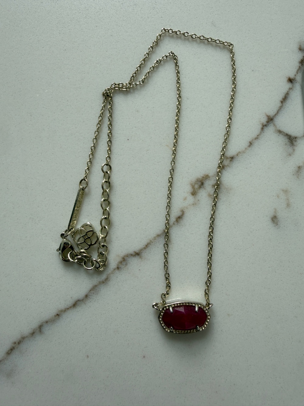 Kendra Scott Necklace: Gold tone chain with dark pink stone